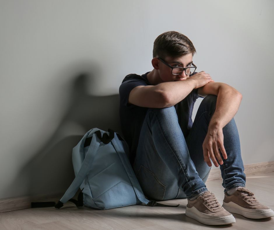 nastolatek smutny siedzi oparty ścianę